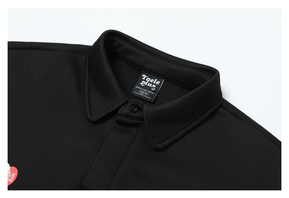 Close-up of a black polo collar, button, and neck label, with part of a red-and-white emblem visible.