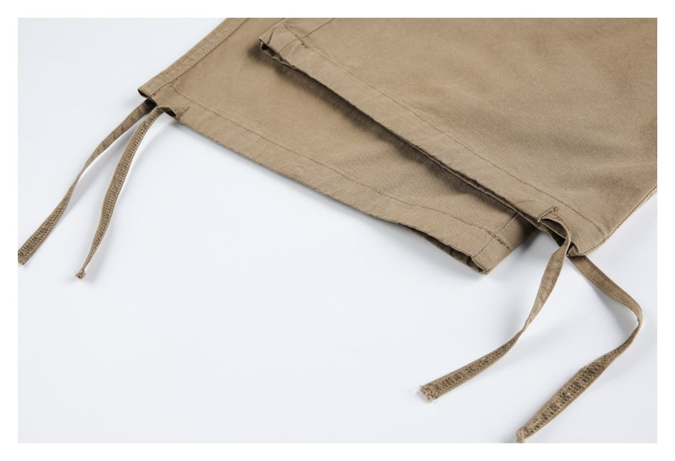 Close-up of khaki pants hems with long adjustable drawstrings.