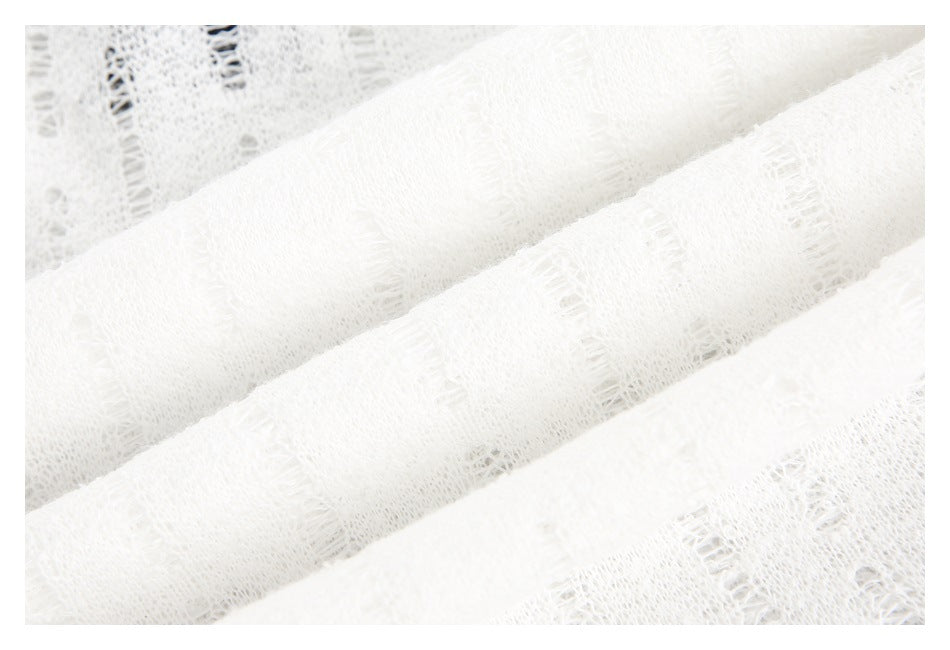 Close-up of soft-looking white fabric with raised rows and open-knit details.