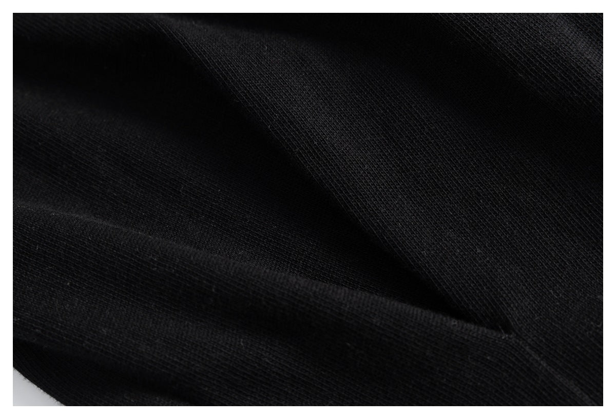 Extreme close-up of the black garment's knit texture and folded fabric.