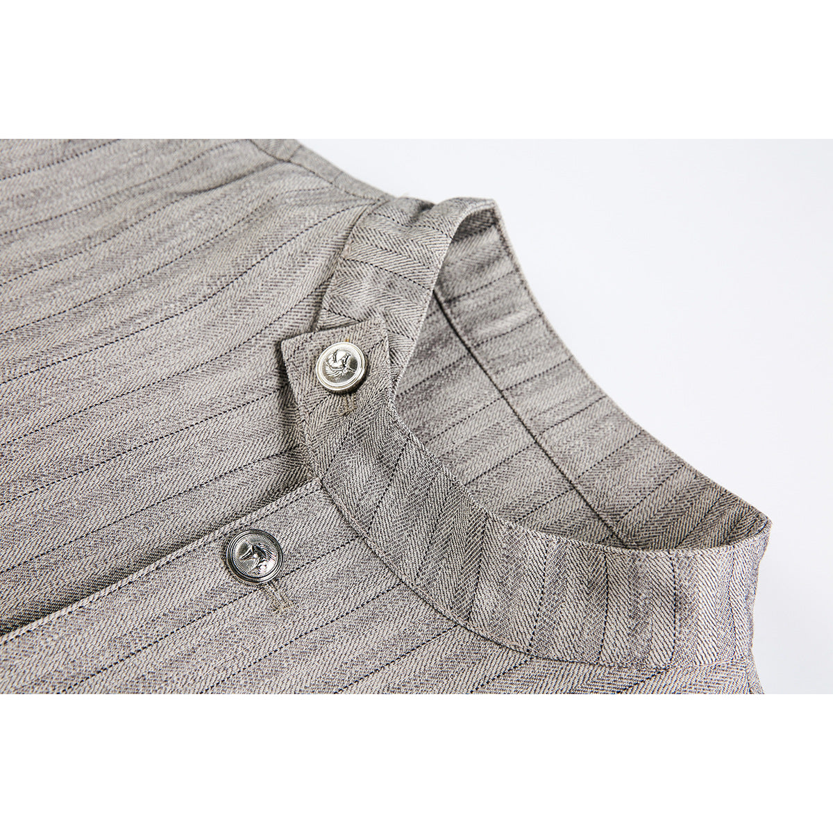 Close-up of a light gray pinstriped jacket collar and two silver-tone buttons.