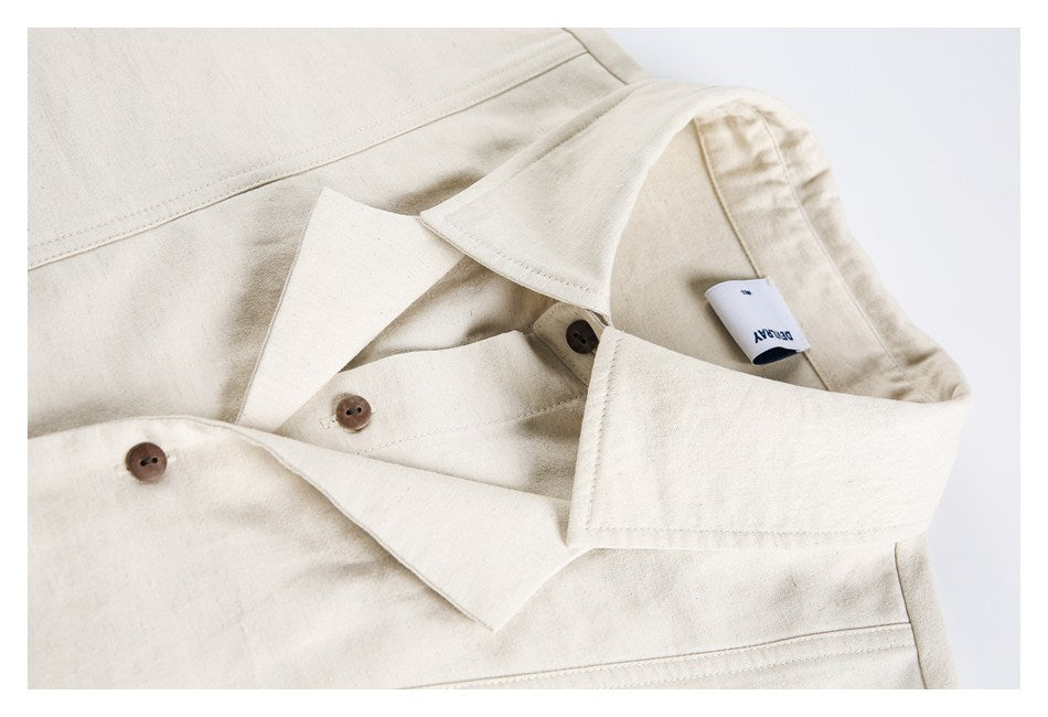Close-up of an ivory shirt collar and brown buttons, with a small white neck label visible.