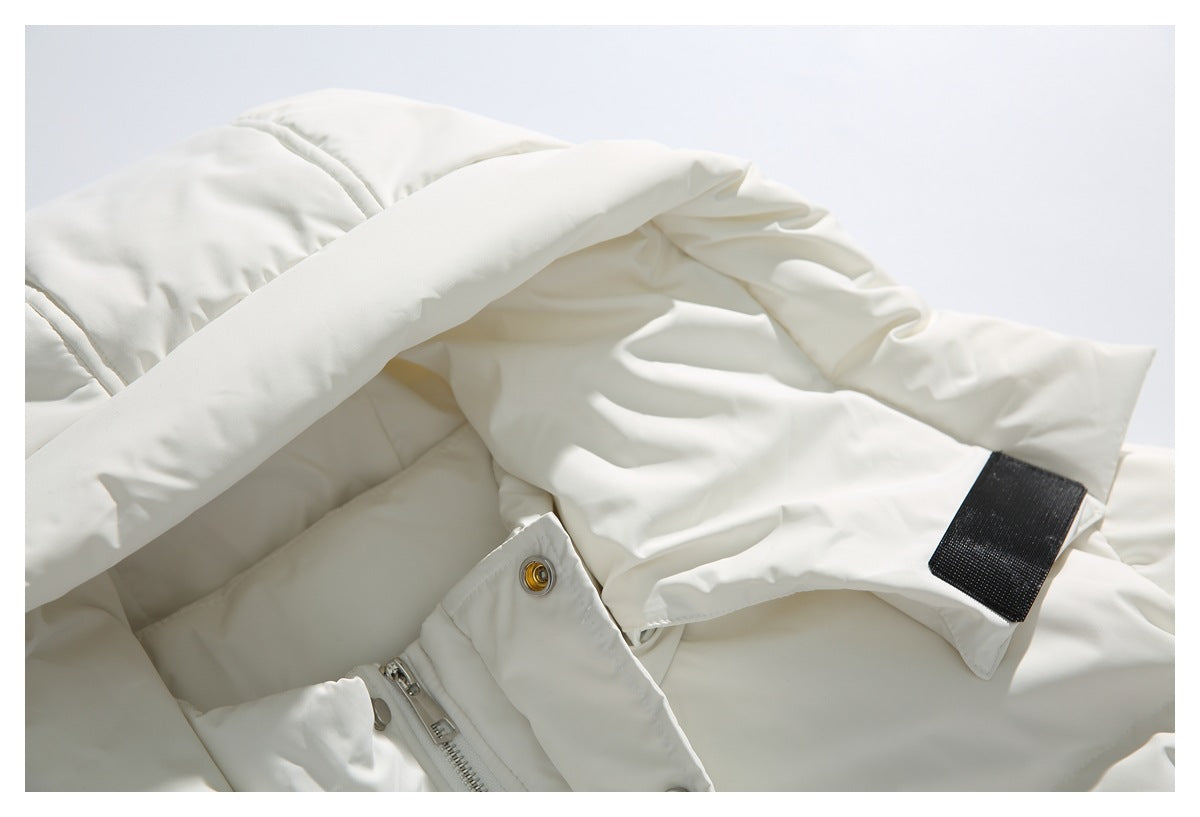 Close-up of the ivory jacket's padded hood, zipper and black hook-and-loop tab.