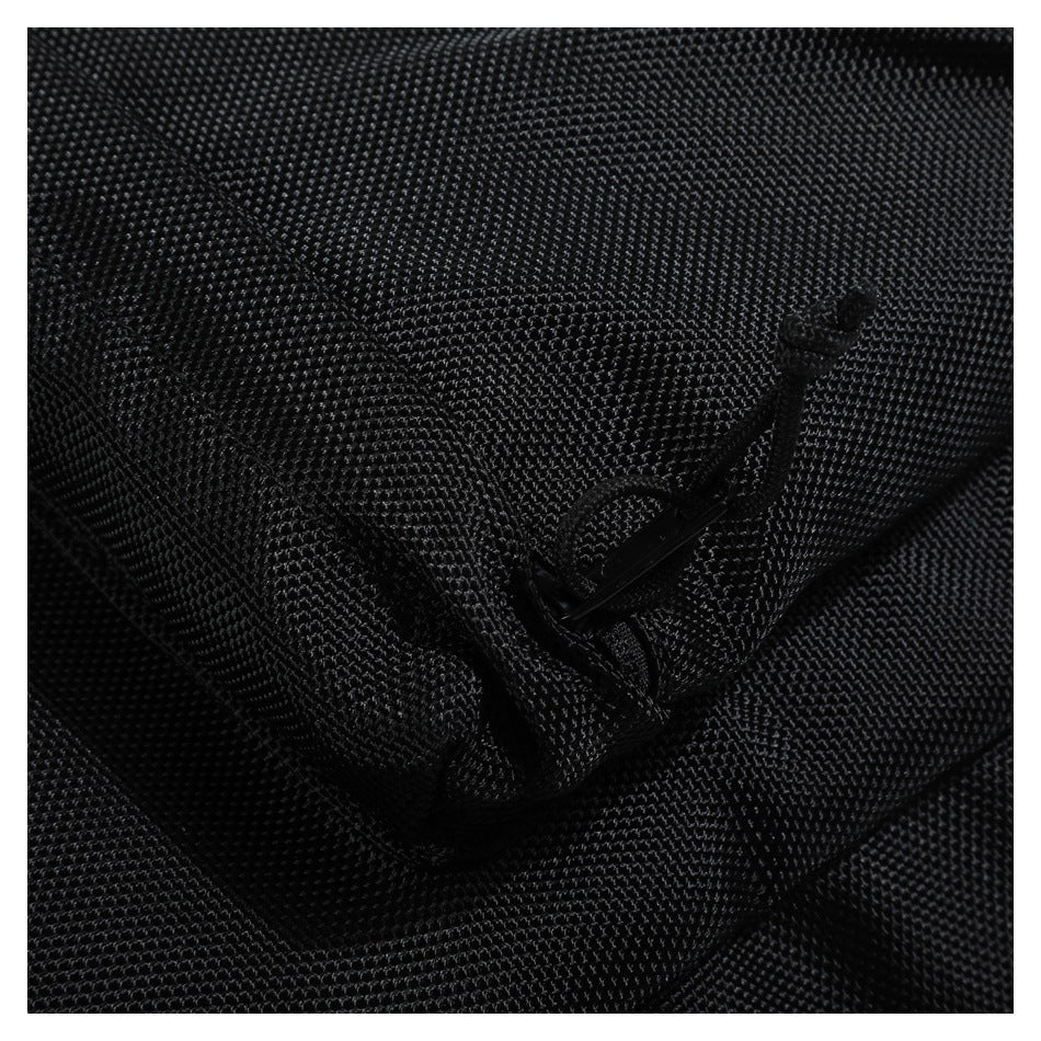 Close-up of a small black zipper pocket on textured backpack fabric.