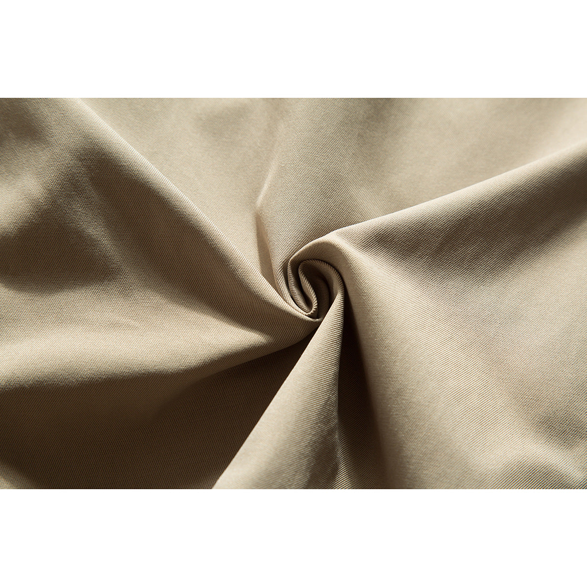 Close-up of beige fabric twisted into a fold, showing its fine diagonal weave.