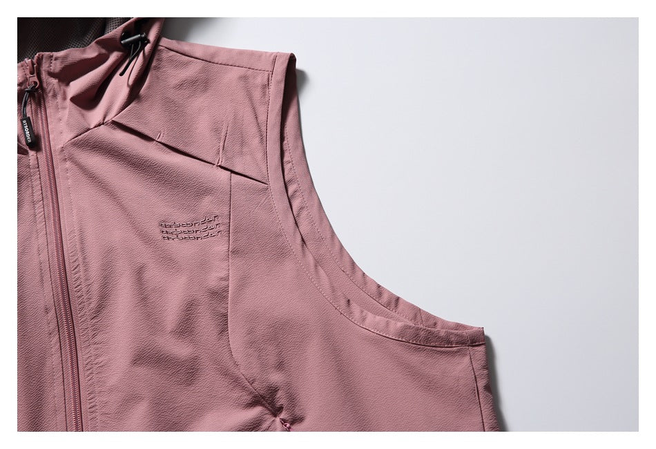 Close-up of the vest's dusty rose front panel, chest embroidery, hood toggle and curved armhole.
