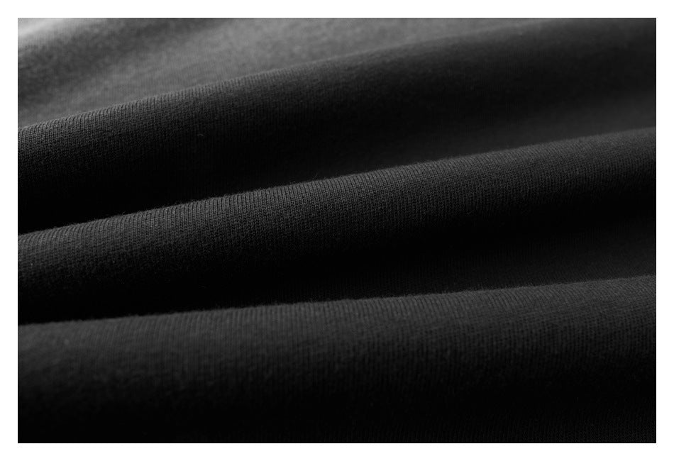Close-up of black fabric gathered into soft folds, showing its fine knit texture.