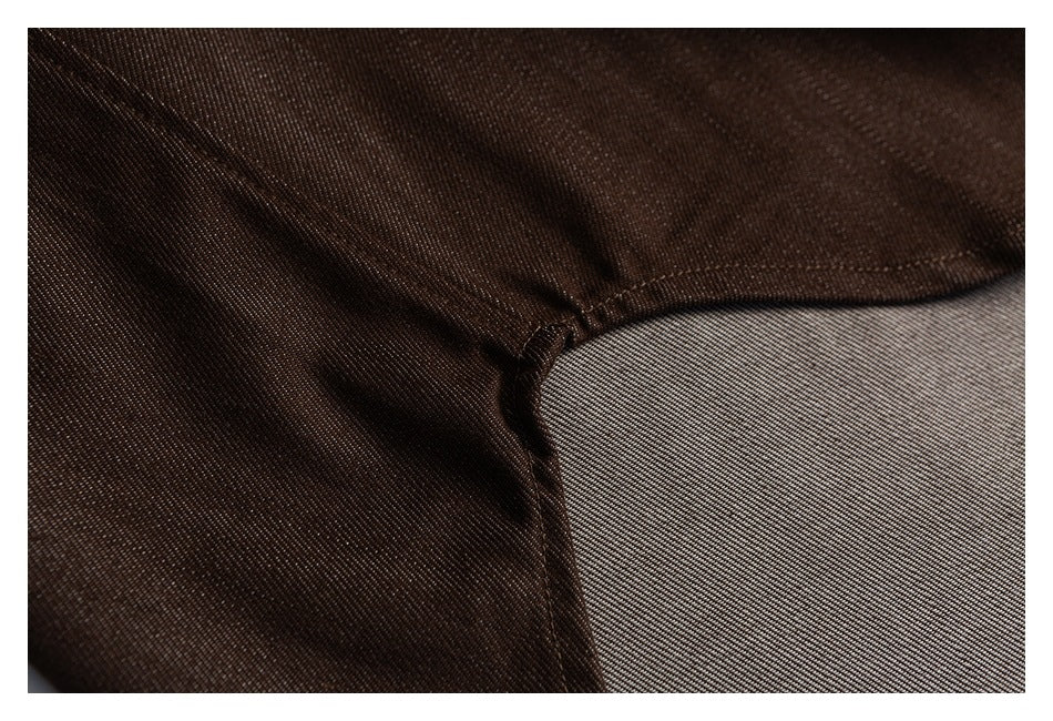 Close-up of a brown shirt's curved hem seam and diagonal fabric texture.