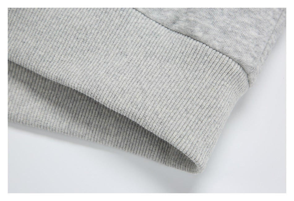 Close-up of a wide ribbed hem on light heather-gray fabric.