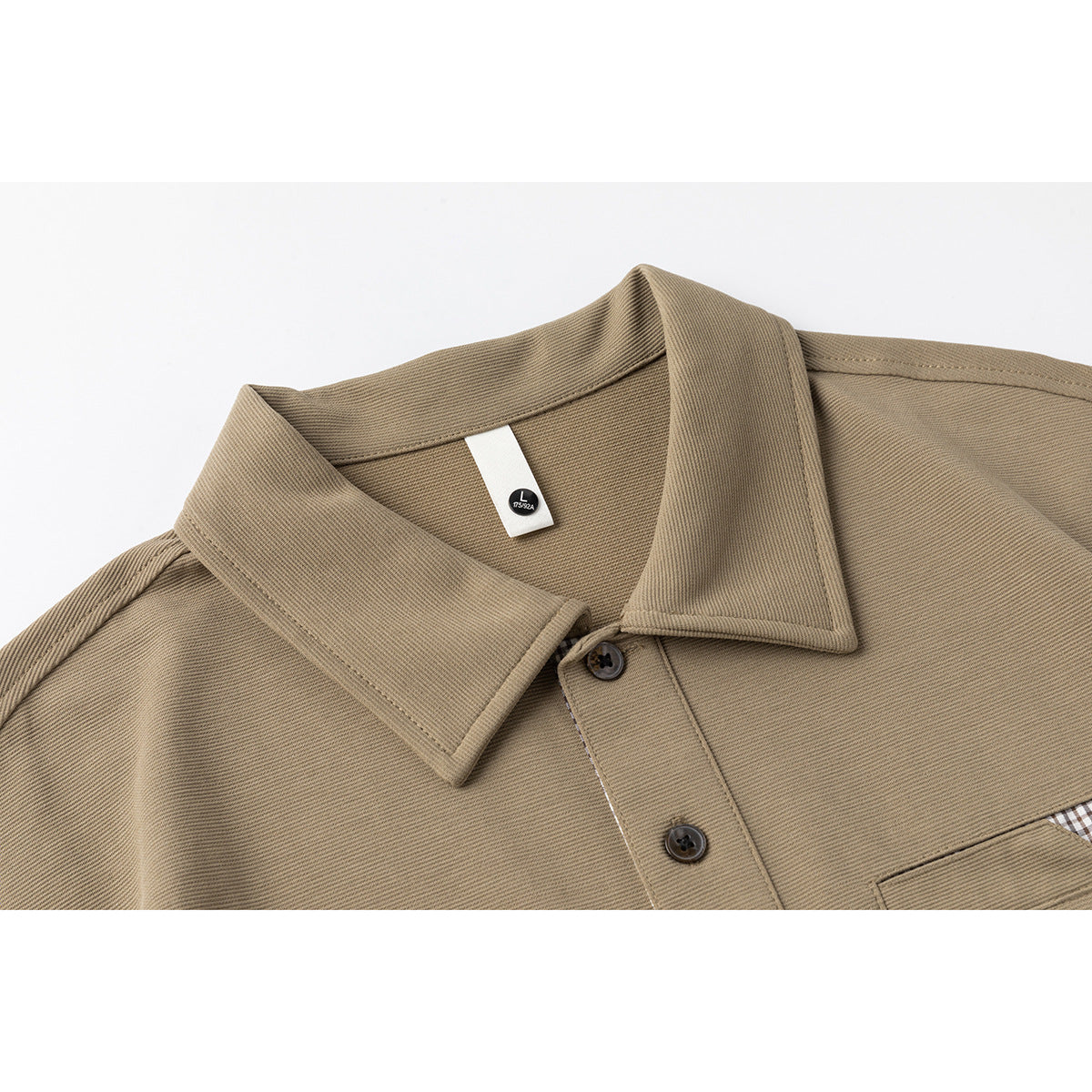 Close-up of a taupe polo shirt collar, button placket, size tag, and edge of the chest pocket.