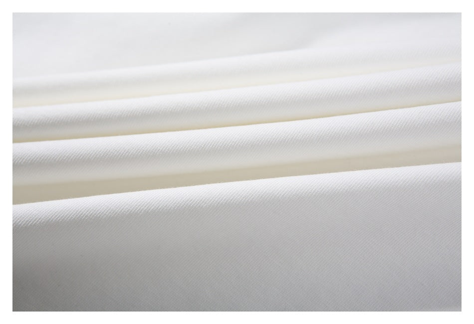 Macro view of the white T-shirt fabric folded into soft ridges.