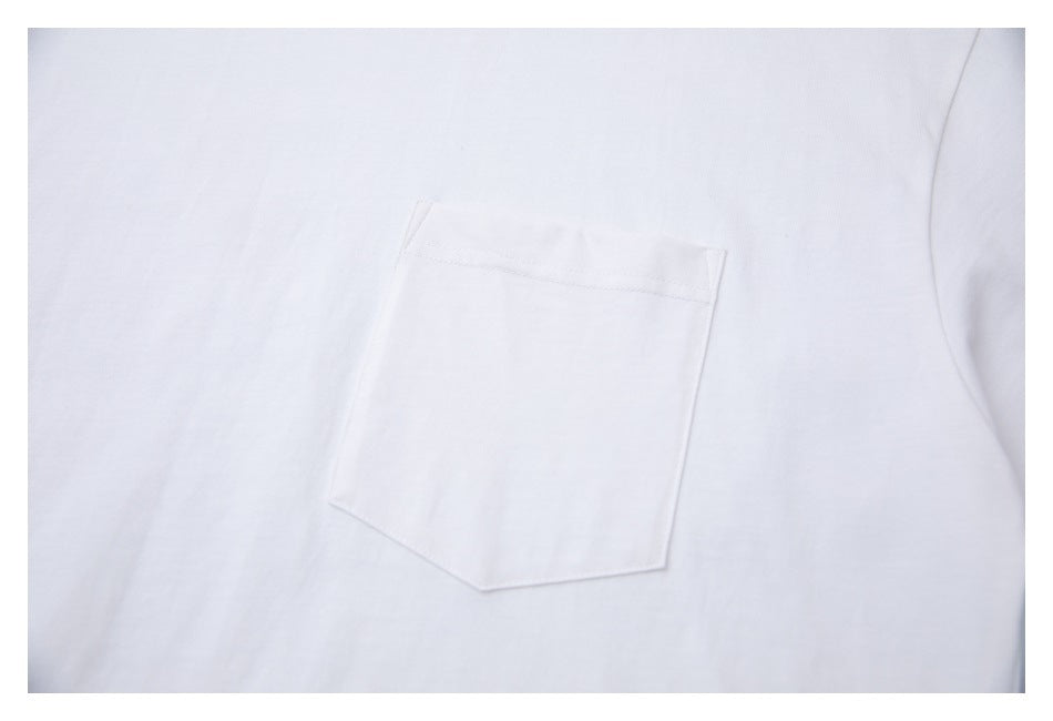 Close-up of a white garment's stitched chest pocket with a pointed lower edge.