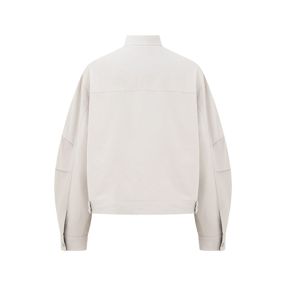 Rear view of a light beige jacket with a short stand collar, long sleeves, button cuffs and adjustable hem tabs.