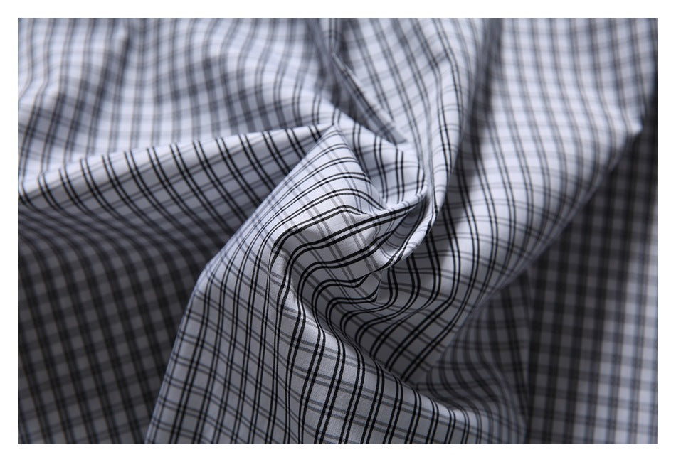 Close-up of black-and-white plaid fabric gathered to show its checked pattern.