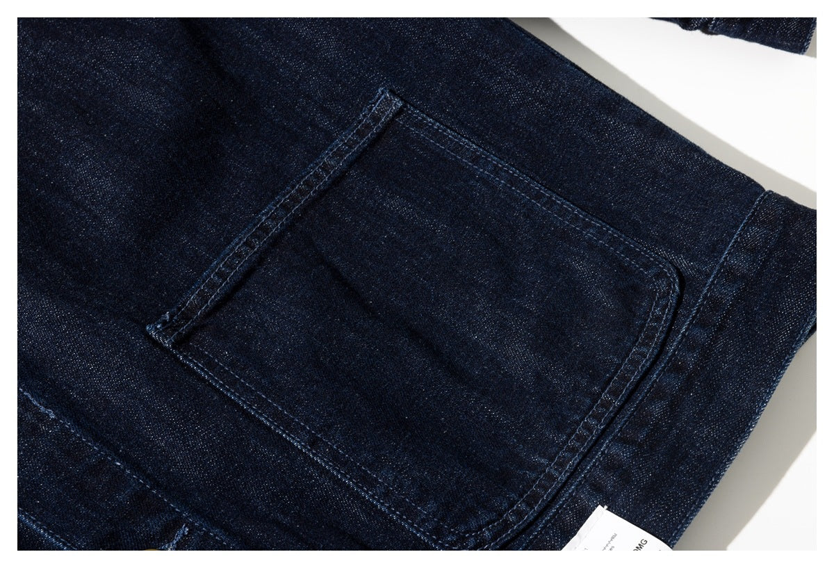 Close-up of a large rectangular patch pocket on dark indigo denim.