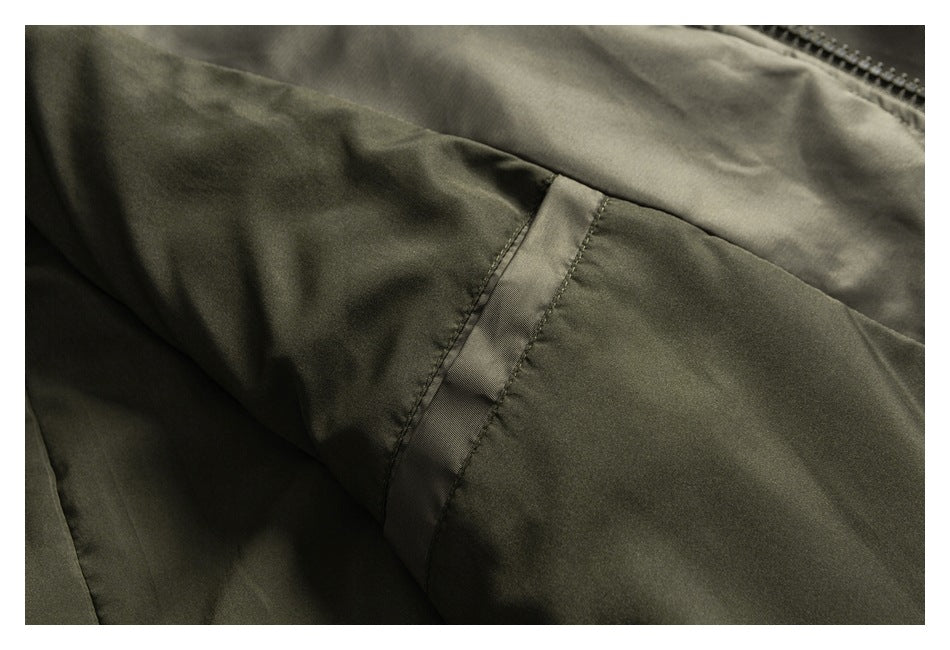 Close-up of an olive jacket pocket opening and stitched fabric panels.