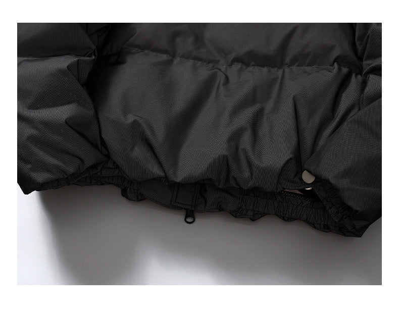 Close-up of the black jacket's gathered lower hem with an adjustment cord and toggle.