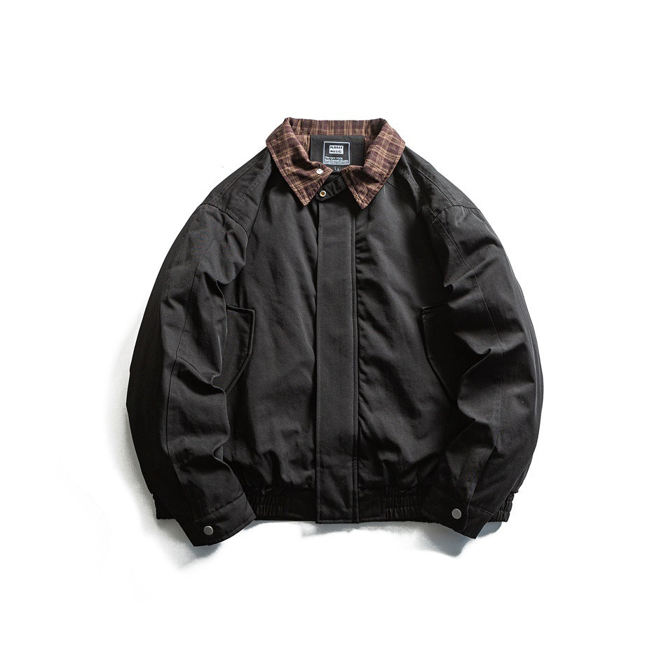 Black jacket with brown plaid collar, covered front placket, side pockets and elastic hem, flat lay
