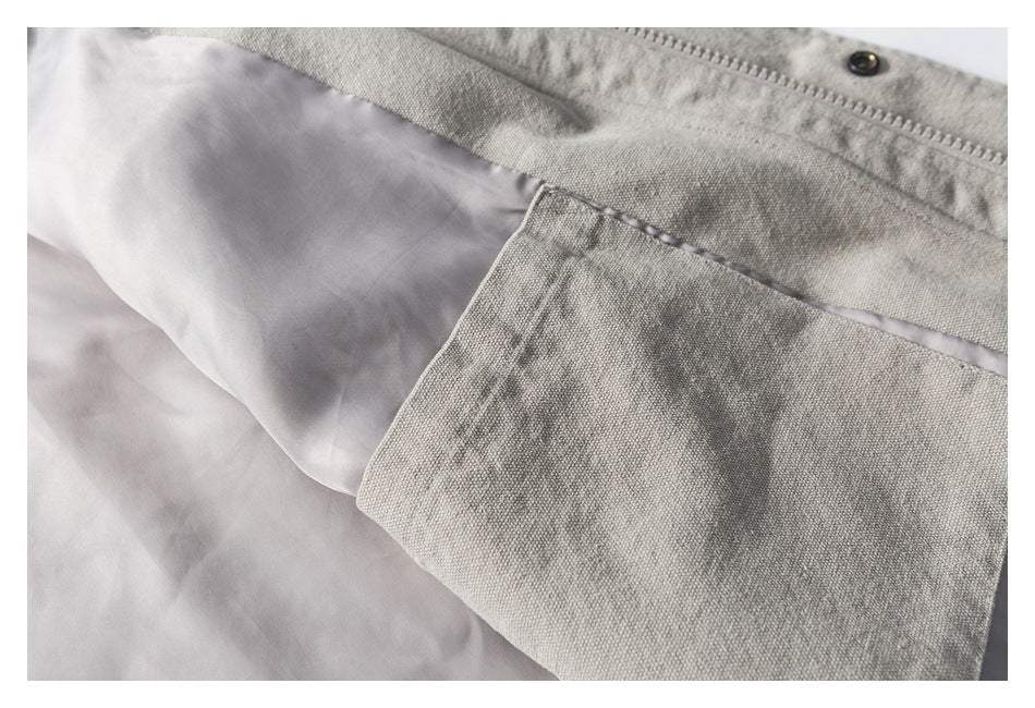 Close-up of the jacket interior, showing pale lining, a fabric pocket, and the zipper edge.