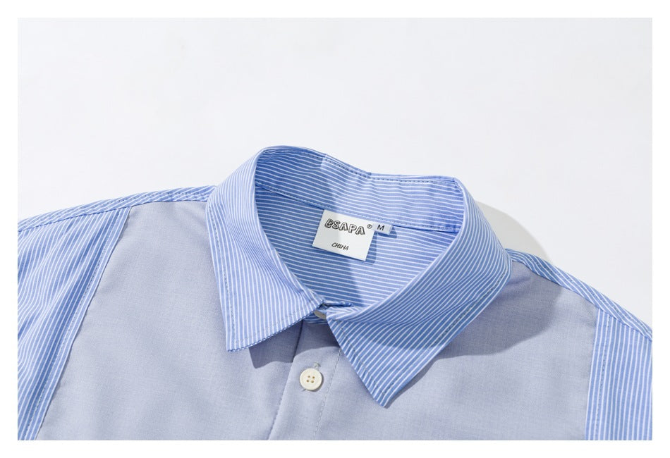 Close-up of a light blue shirt collar with blue-and-white striped panels, a button, and the neck label.