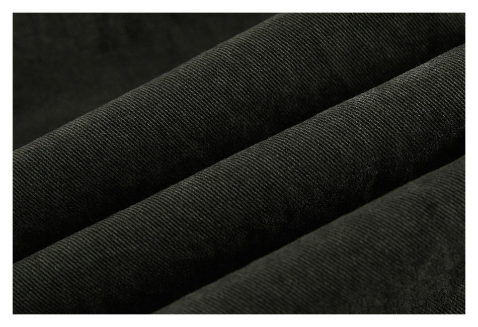Close-up of dark charcoal fabric folded into ridges, showing its fine diagonal weave.