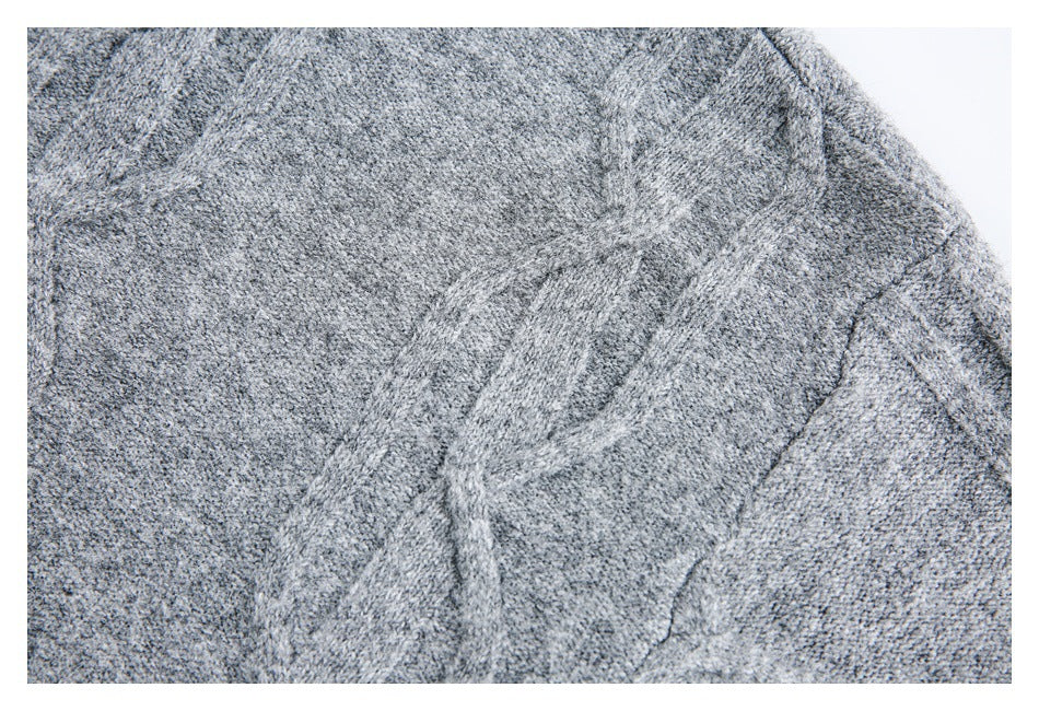 Close-up of raised cable-knit detailing on a heather gray garment.