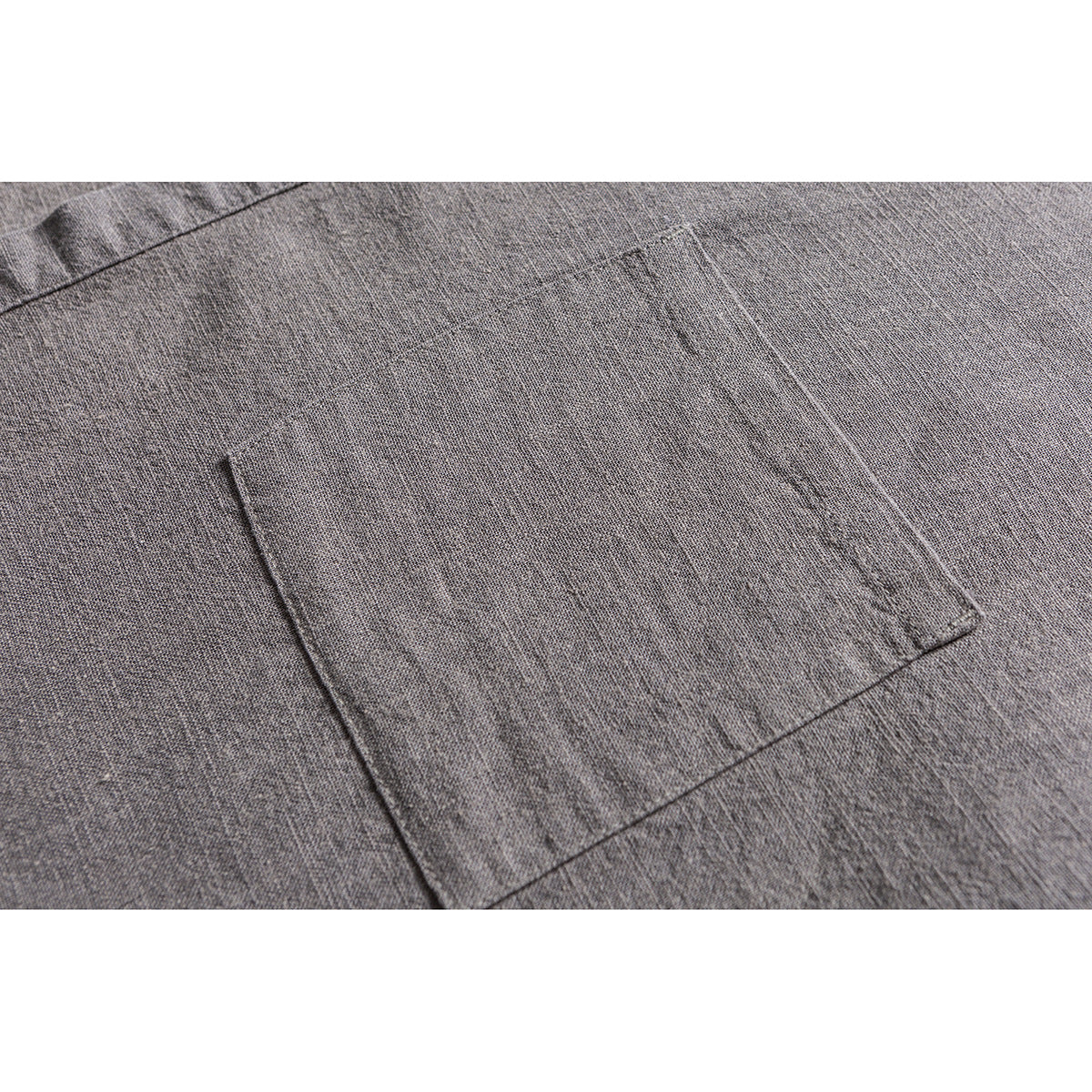 Close-up of a rectangular patch pocket on gray woven shirt fabric.