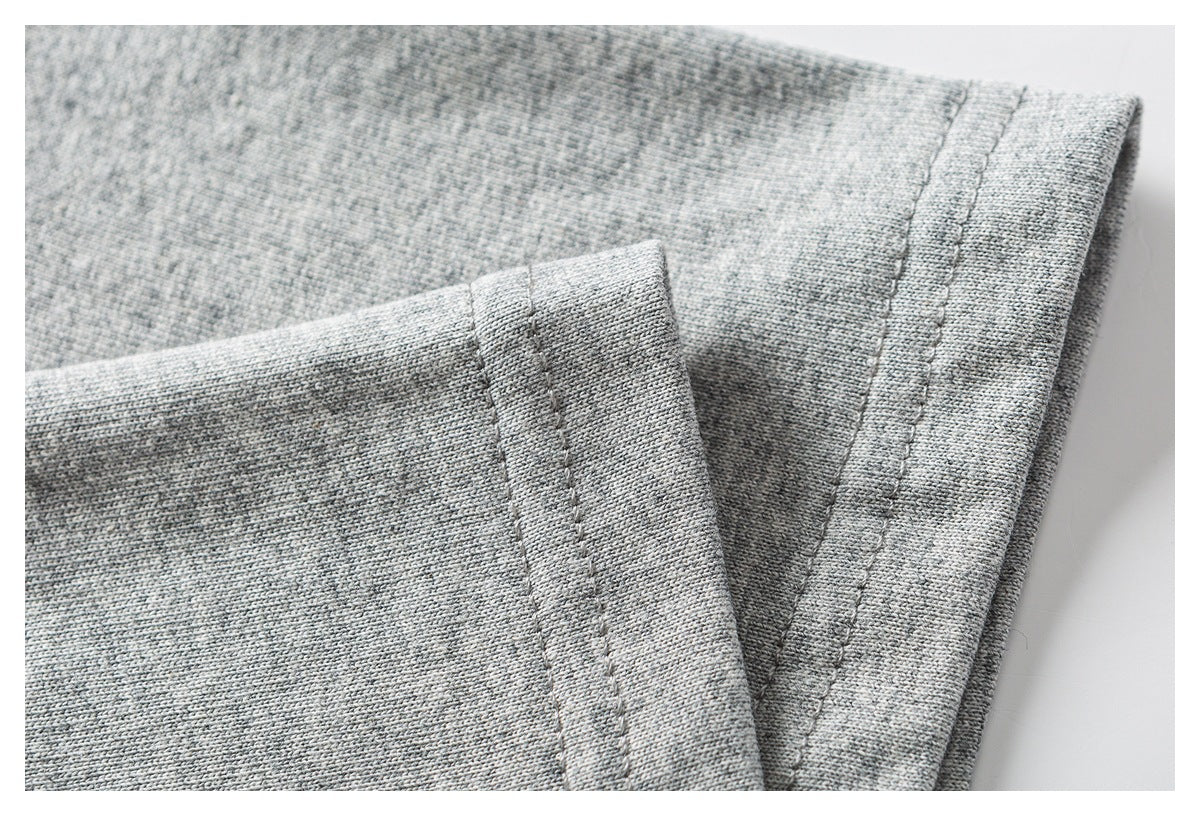 Close-up of heather-gray garment fabric and a neatly stitched folded edge.