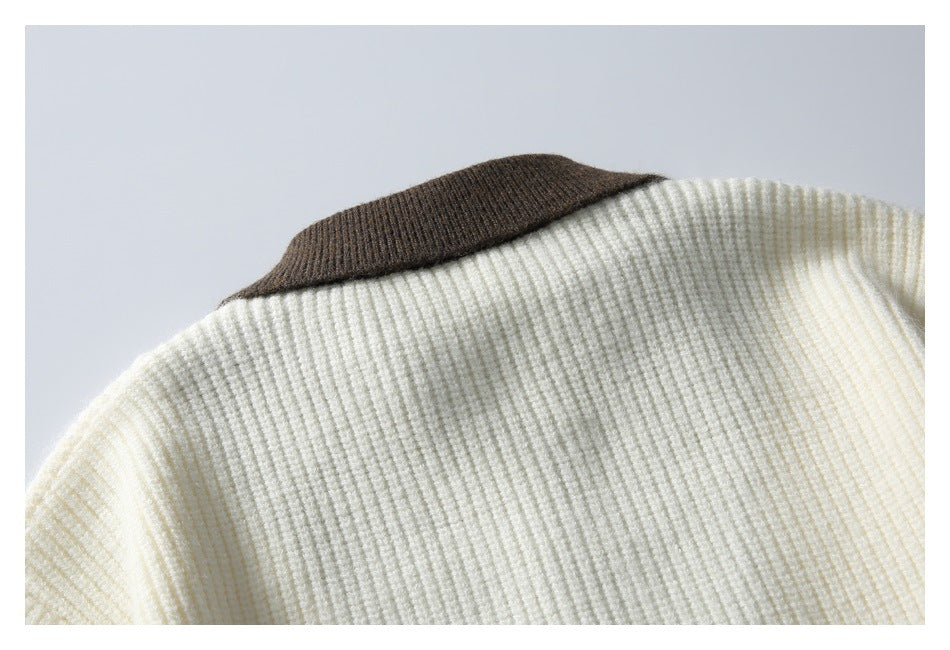 Close-up of an ivory rib-knit sweater with a dark brown contrast collar.