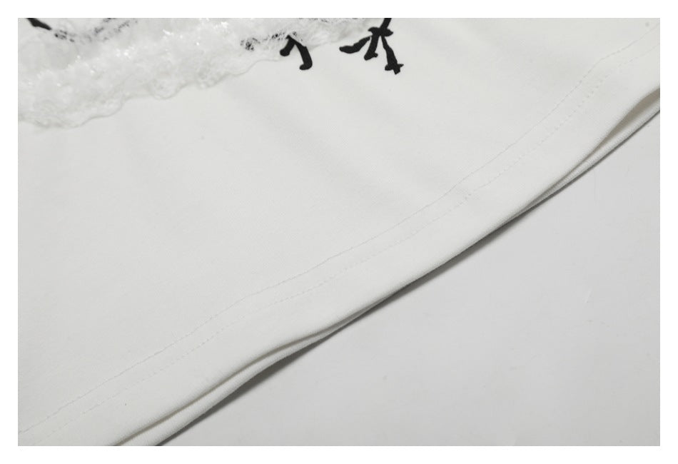 Close-up of the white garment's curved hem stitching, with a small portion of lace and black print visible.