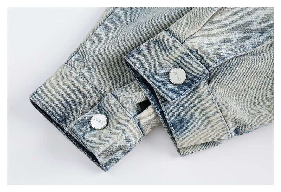 Close-up of light blue denim jacket cuffs with buttoned tabs.