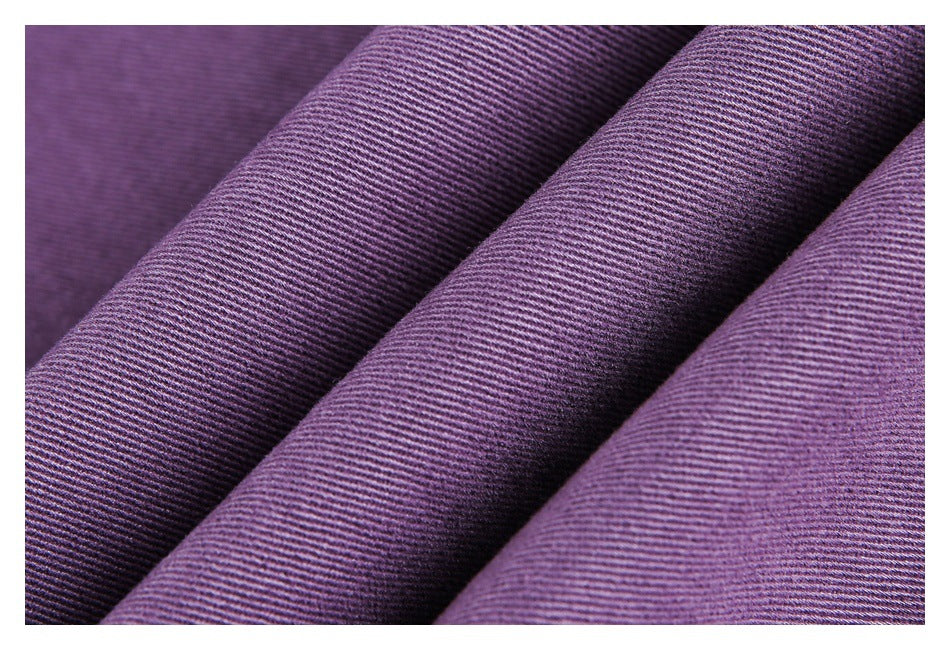 Close-up of purple fabric draped in folds, showing its fine diagonal weave.
