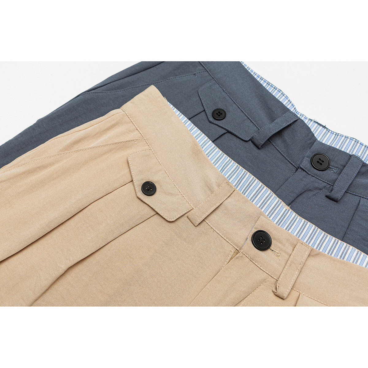 Close-up of tan and slate gray shorts waistbands with black buttons and blue-and-white striped inner waistbands.