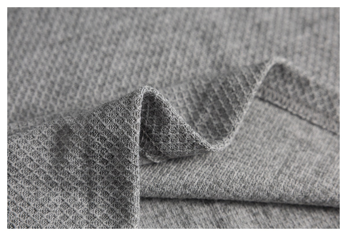 Close-up of the gray textured top's folded fabric and stitched seam.