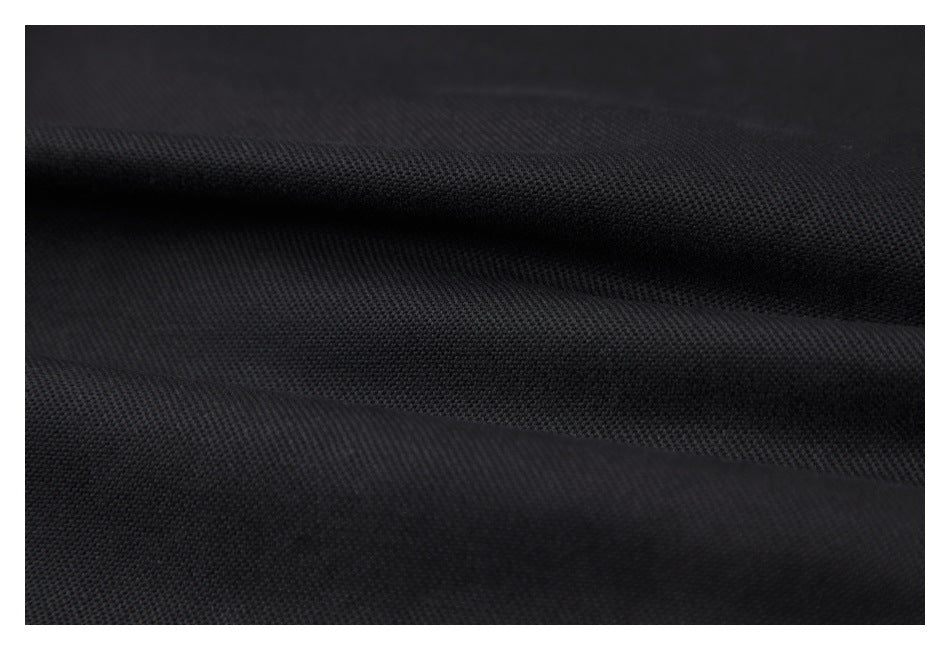 Close-up of black fabric with a fine, slightly textured weave and soft folds.