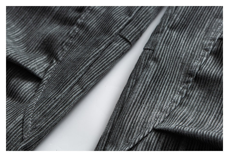 Close-up of dark charcoal ribbed garment fabric showing stitched seams and folded edges.