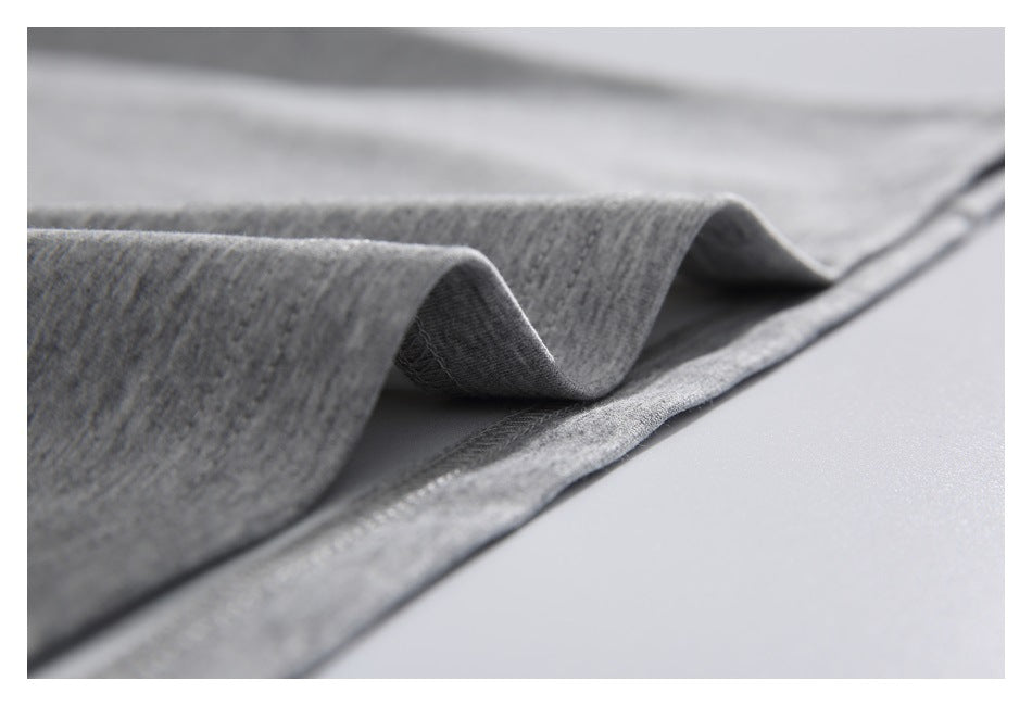 Close-up of heather gray knit fabric folded to show its texture and stitched edge.
