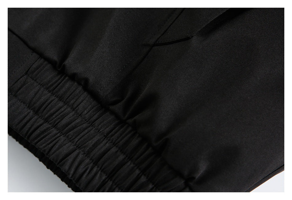 Close-up of the black jacket's gathered elastic hem and nearby stitching.