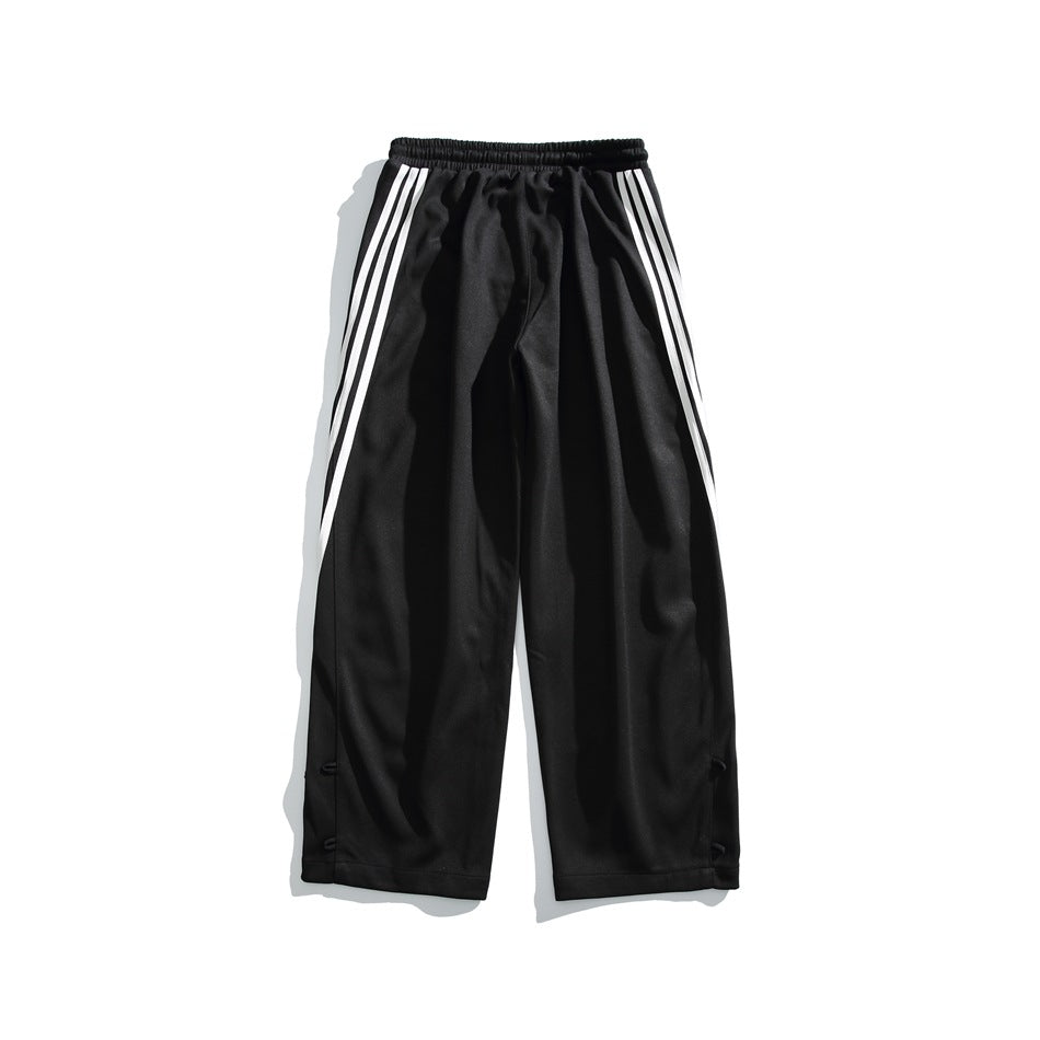 Front view of black wide-leg track pants with an elastic waistband and three white stripes along each side.