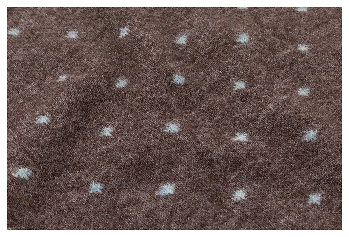 Close-up of brown knit fabric with scattered small pale blue motifs.