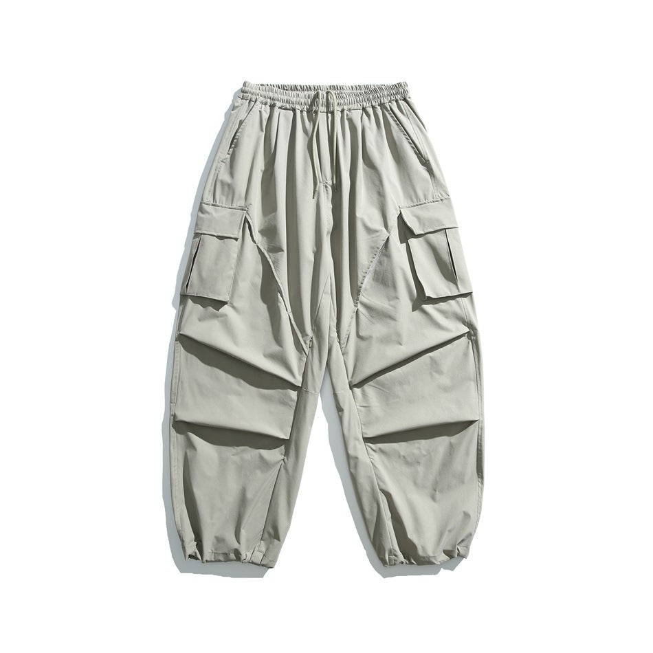 Gray-green wide-leg cargo pants with drawstring waist, flap thigh pockets and gathered hems, flat lay