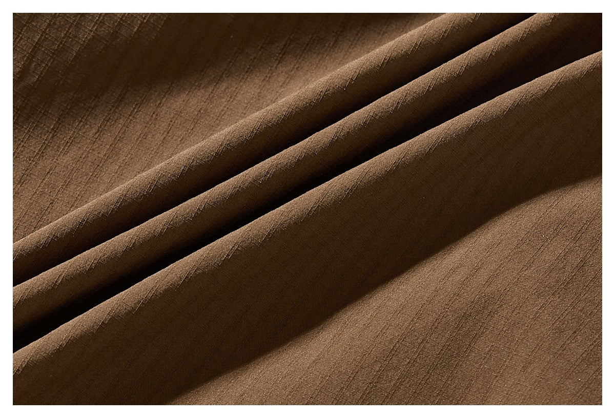 Close-up of brown woven fabric arranged in broad diagonal folds.