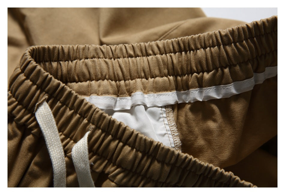 Inside close-up of tan bottoms showing the gathered elastic waistband, white drawstrings, and inner seam finish.