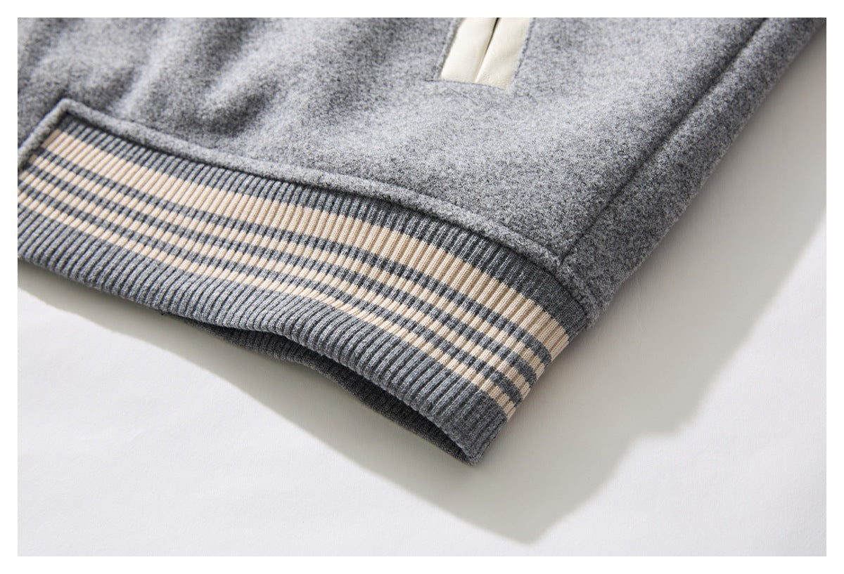 Close-up of a gray garment hem with ribbing and cream and charcoal stripes.