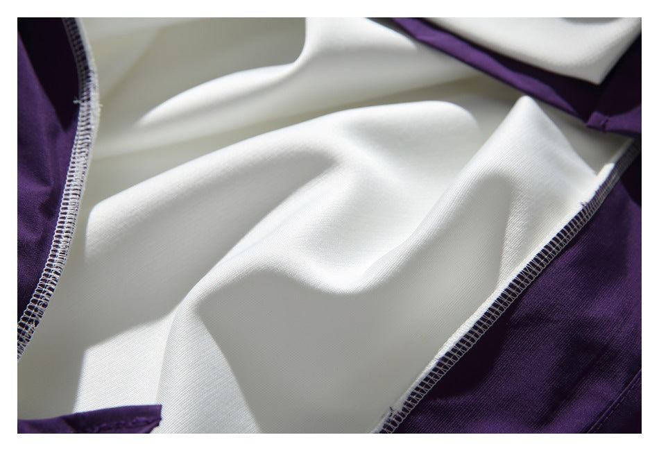 Close-up of white and dark purple garment panels with visible overlock seams.