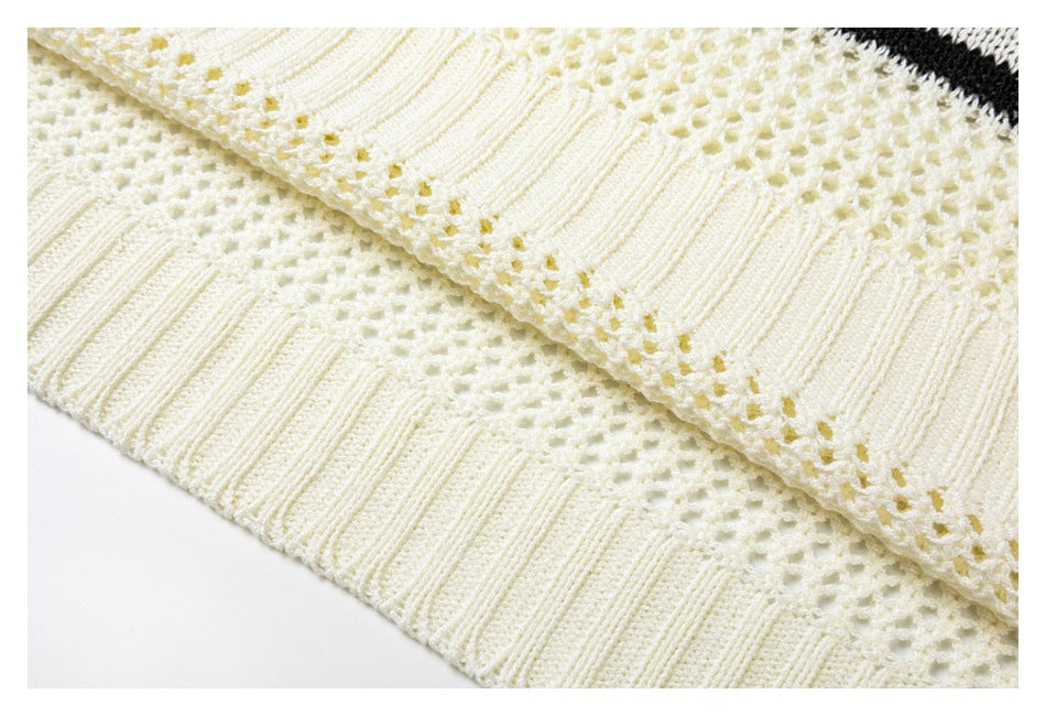 Close-up of cream open-knit fabric with a wide ribbed edge.