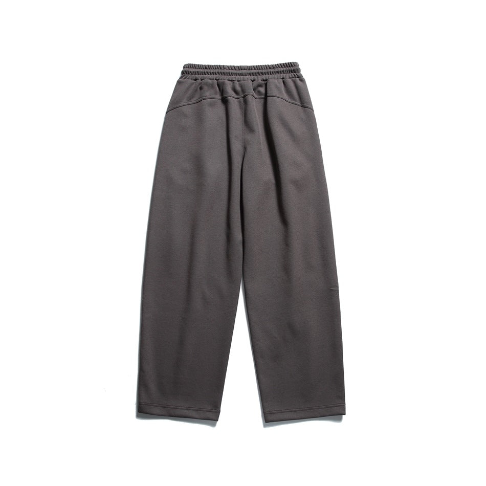 Dark charcoal wide-leg sweatpants shown from the front with an elastic waistband and drawstring.