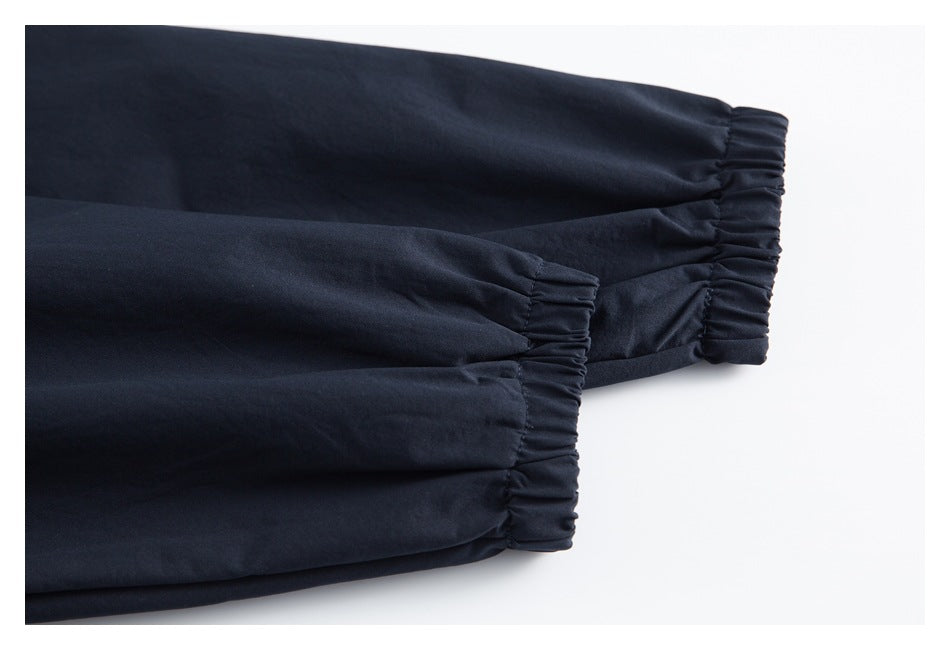 Close-up of two navy garment legs ending in gathered elastic cuffs.