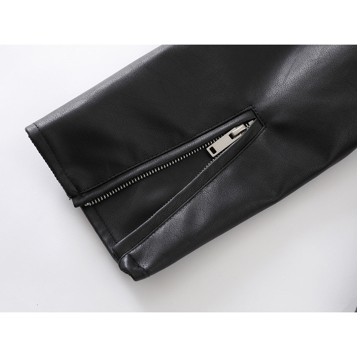 Close-up of a black jacket sleeve with a silver zipper at the cuff.