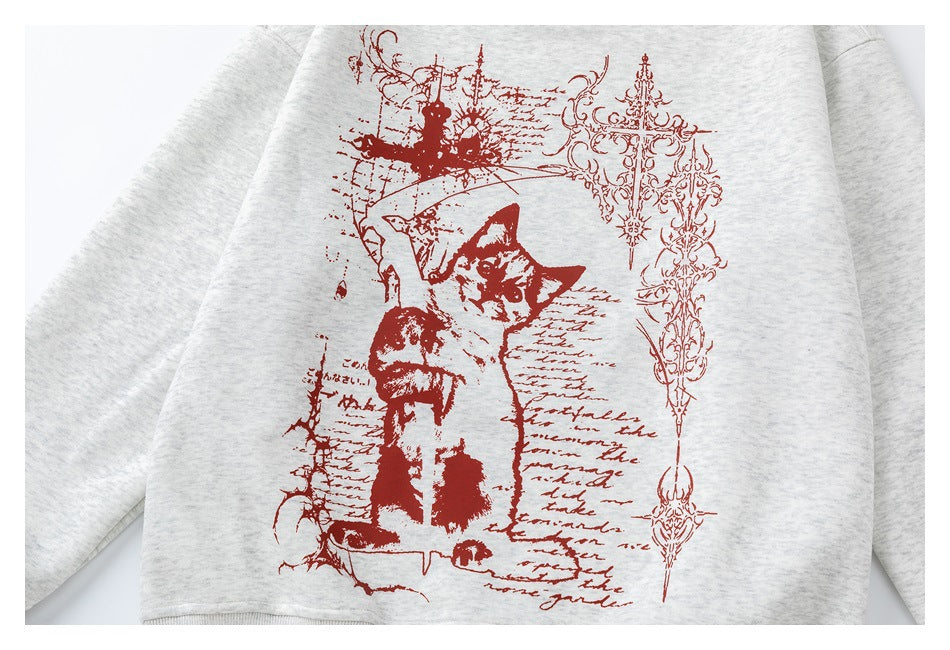 Close view of a light gray heather crewneck sweatshirt with a large red vintage-style cat and script graphic.